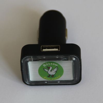 USB-Stick für PKW-Nutzung am Zigarettenanzünder. Als Logo ist eine weiße Gans auf grünem Kreis dargestellt. Schriftzug in weiß/gelb "Bützow ...Gans anders"